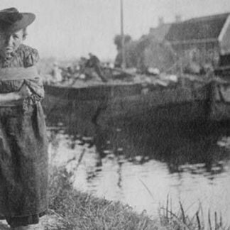 A Older Dutch woman has a bustle around her chest as she pulls a barge down a canal