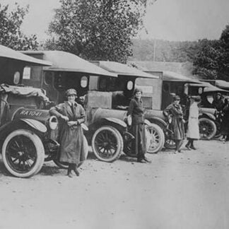A line of Women Ambulance Drivers with their vehicles