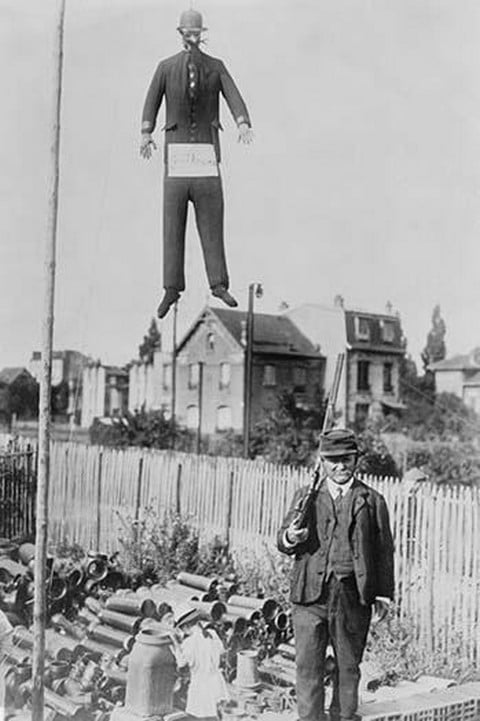 An old man carrying a rifle guards a hanging effigy of Kaiser Wilhelm