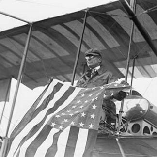 Aviator C.B. Harmon Unfurls Stars and Stripes from his pilot seat on his Biplane