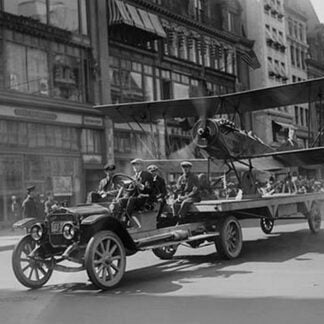 Biplane with spinning propeller is towed down Fifth Avenue New York for July 4th Parade