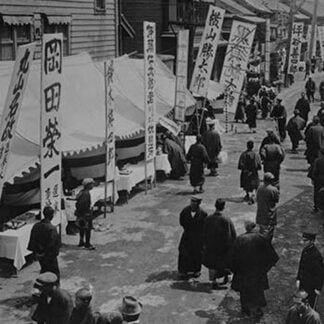 Election Day in Tokyo Japan shows a line of tables with signs in Kanji advertising political candidates