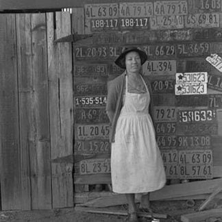 Farm woman beside her barn door by Dorothea Lange