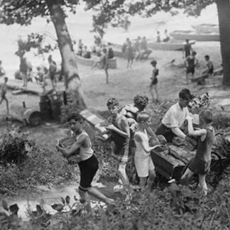 Group of Boys carry loaves of bread from wagons near Beach front in woods.