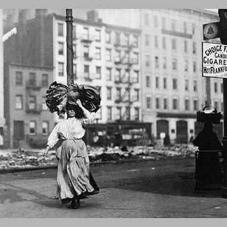 Immigrant Woman Walks Down Street Carrying a Pile of Clothing on Her Head