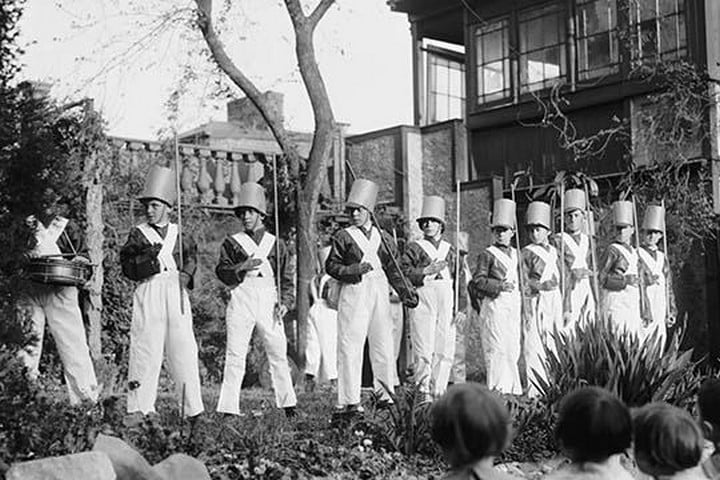 Line of Boys pose as Soldiers with inverted pails on their heads