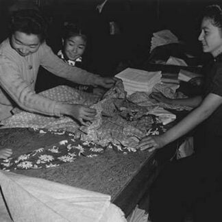 Mrs. Nakamura and family buying clothing by Ansel Adams