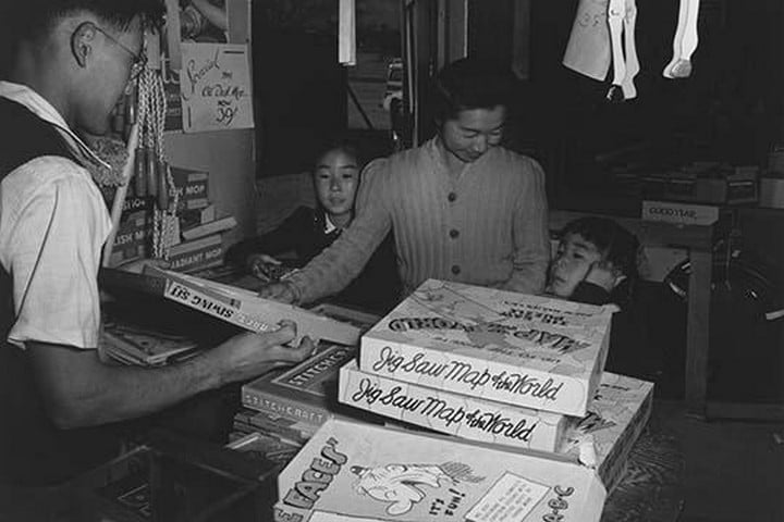 Mrs. Yaeko Nakamura and family buying toys with Fred Moriguchi by Ansel Adams