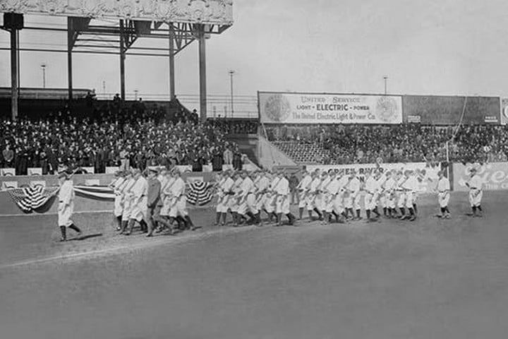 New York Yankees show support for the Troops in World War I by marching around the stadium on baseball uniforms and carrying rifles over their shoulders