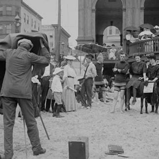 Photographer taking picture of group with donkey at crowded Beach