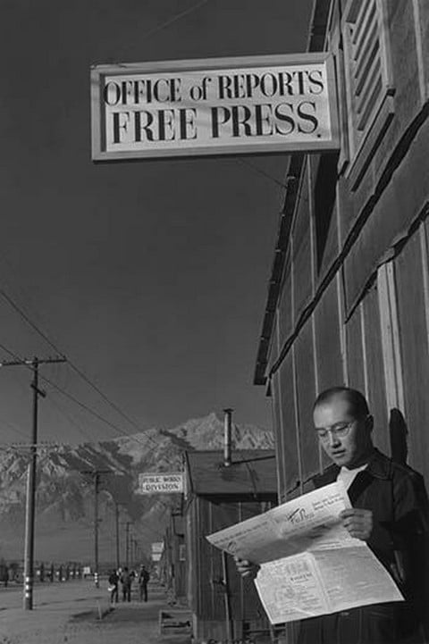 Roy Takeno Reading Paper in Front of Office by Ansel Adams