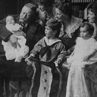 Teddy Roosevelt holds a baby in his arms in a Family Portrait