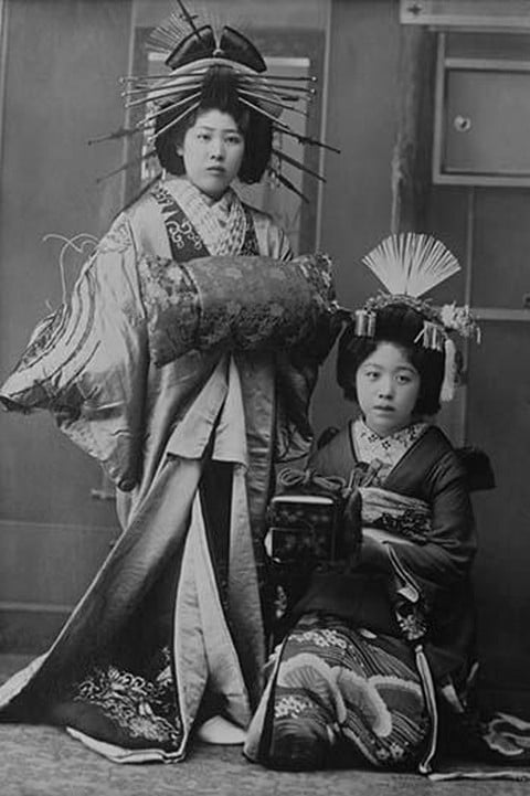 Two Young Beautiful Japanese Geishas in Ceremonial Costumes and Hairstyles of Ancient Japan with Kimono