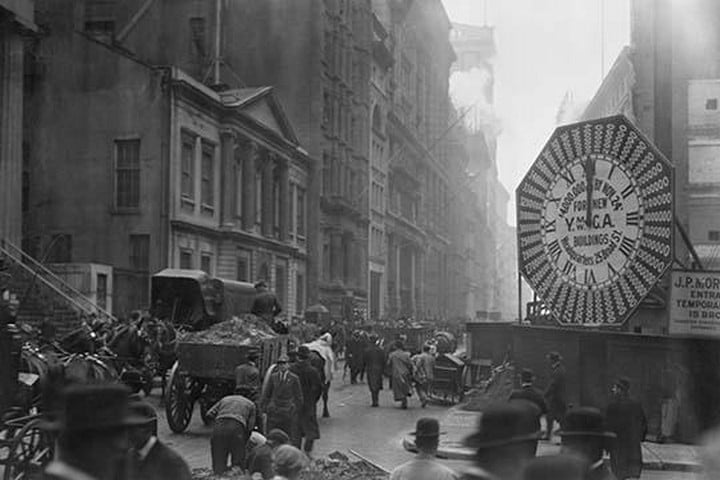 Wagons Trundle Along Manhattan Streets Past a YMCA Clock Sign