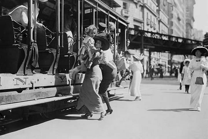 Woman lifts Child off of an open sided Trolley Car on New York's Broadway